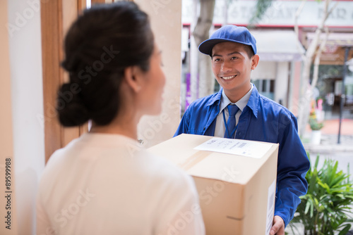 Cheerful Asian postman © DragonImages