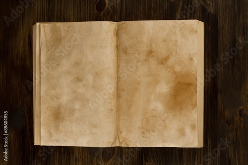 open old vintage book on the aged wooden background. Two clean sheet of paper.