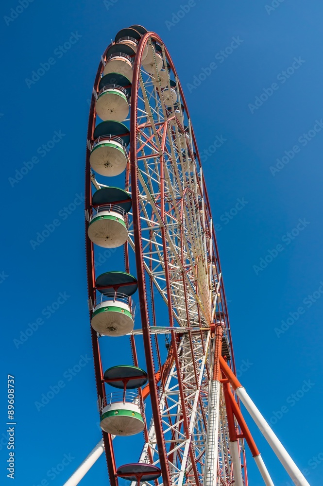 Underside view of a ferris wheel on sky background
