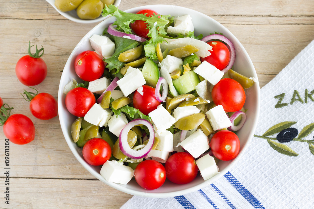 Greek salad on a wooden table, up view. Greek salad on a wooden table, up view.
