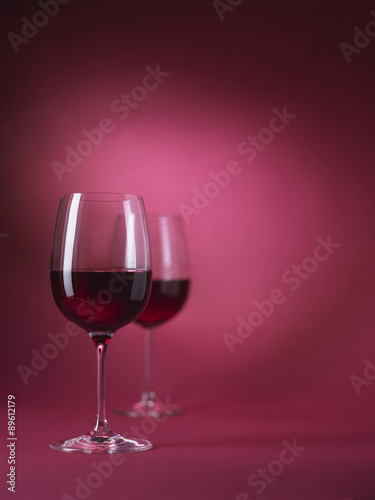 2 red wine glasses on red