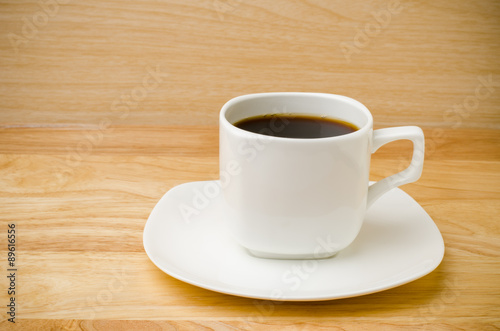The cup of hot coffee on wooden background