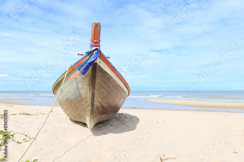 Wooden fishing boat on the beach with blue sky