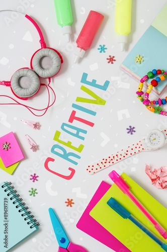 Photo of workplace with lots of stationery objects and headphone