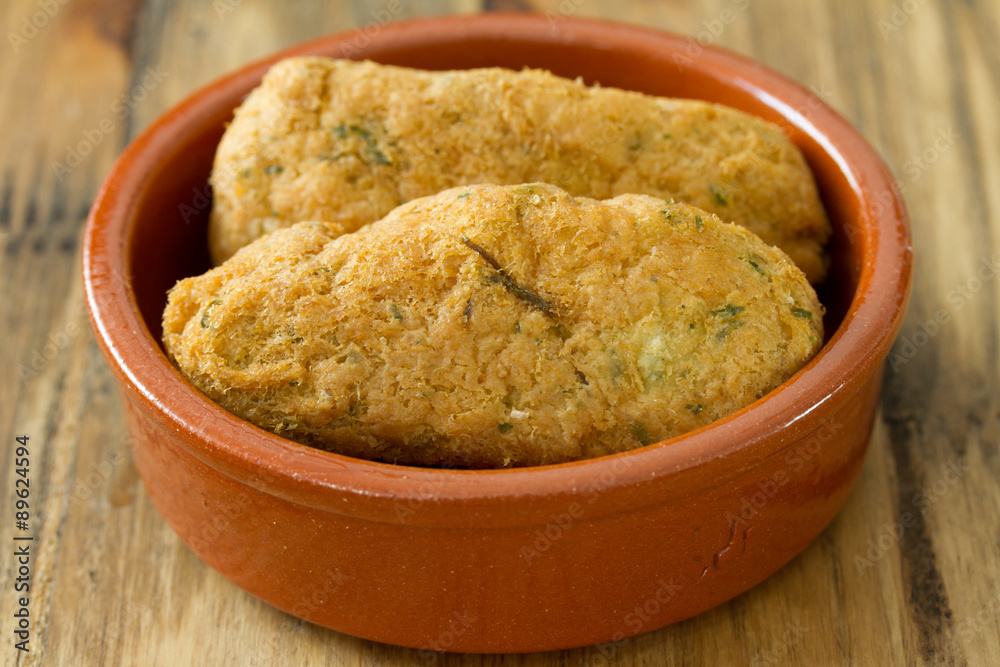 cod fish croquettes on dish on brown background cod fish croquettes on dish on brown background