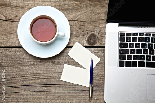 on vintage table tea,laptop and business cards