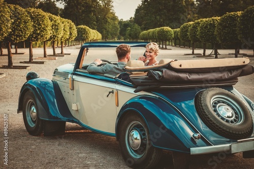 Wealthy couple in classic convertible © Nejron Photo