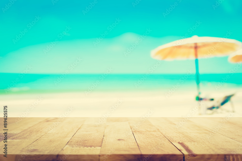 Wood table top on blurred blue sea and white sand beach background Wood table top on blurred blue sea and white sand beach background