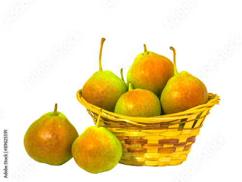 Pears are in the basket. Two pears lie nearby. Composition on a white background.