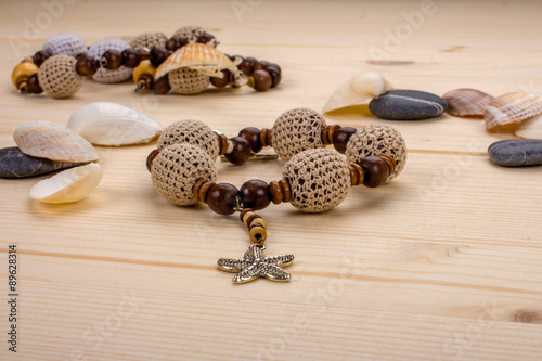 Bracelet handmade crochet beads with pendant starfish on a woode