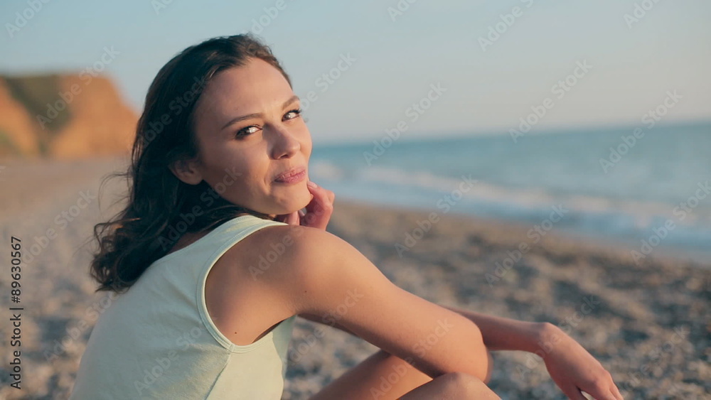Seductive pretty girl sitting on the beach near the sea Seductive pretty girl sitting on the beach near the sea
