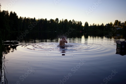 Adult man splash water in forest lake