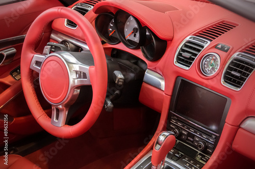Red luxury car Interior - steering wheel, shift lever and dashbo © vchalup