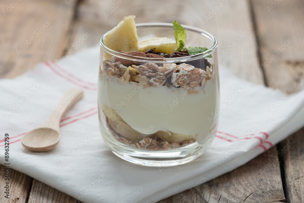 Yogurt with muesli and banana in small glass. Yogurt with muesli and banana in small glass.