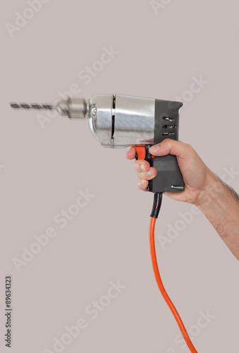 Man's hand holding a drill