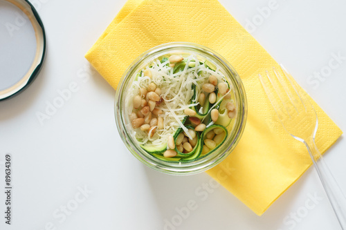 Zucchini carpaccio with Parmesan cheese and pine nuts in jar