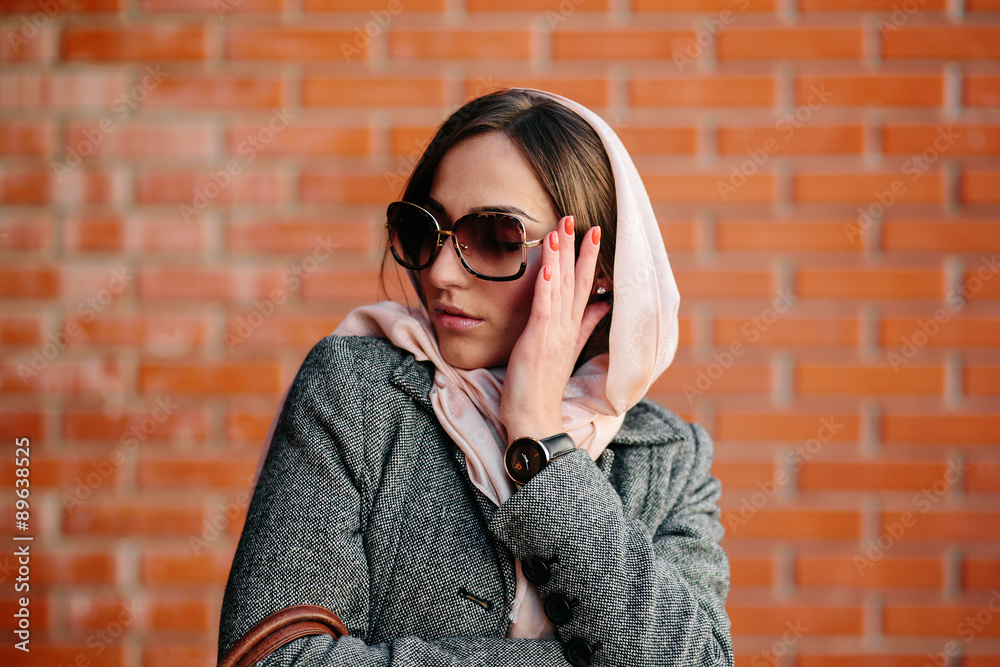 girl posing on a background of red brick wall