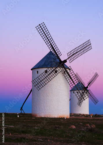 Two windmills at field in evening