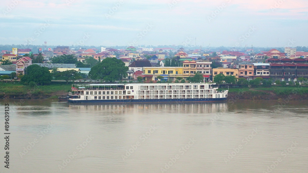 River cruise ship docked in Mekong river and small picturesque town River cruise ship docked in Mekong river and small picturesque town