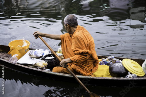 monk is rowing the boat,looking for who want to  almsgiver . © ptrwd