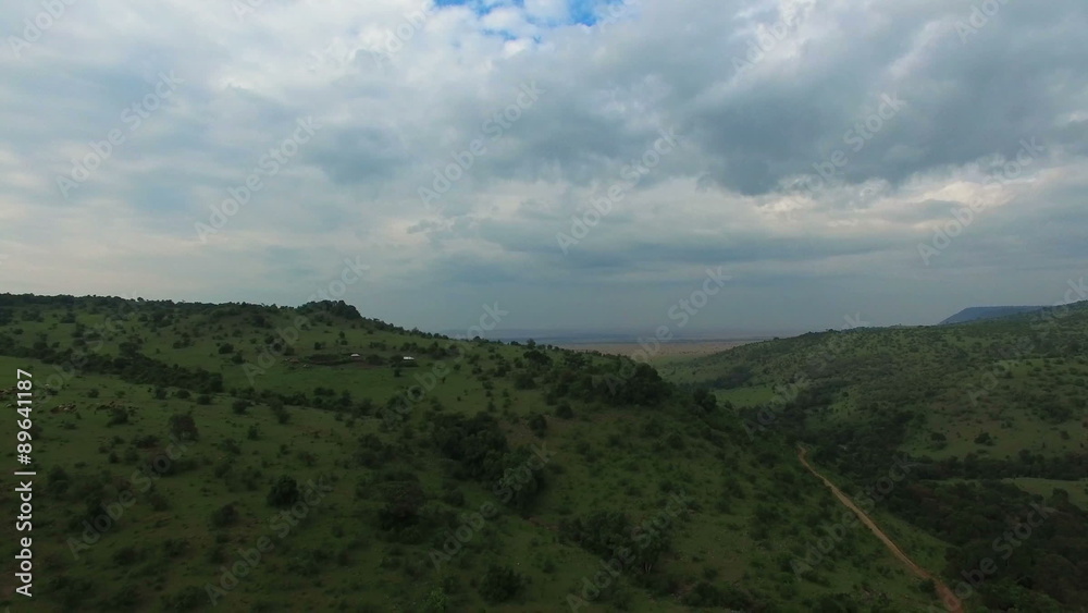 Aerial view flying up over mountains in Masai Mara. Africa. Kenya. Masai Mara savanna bird eye view. Travel tourism adventure in wild animal nature. Aerial view flying up over mountains in Masai Mara. Africa. Kenya. Masai Mara savanna bird eye view. Travel tourism adventure in wild animal nature.