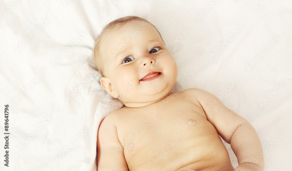Portrait of smiling baby lying on the bed at home, top view Portrait of smiling baby lying on the bed at home, top view