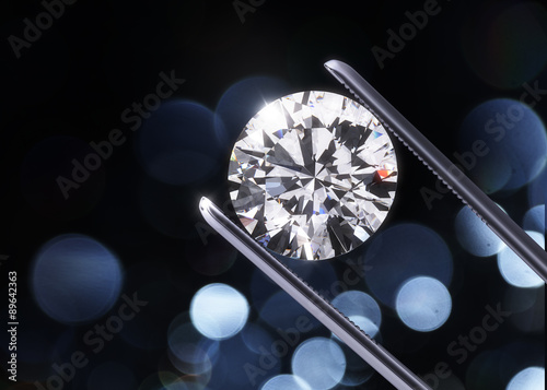 Obraz na płótnie Luxury diamond in tweezers closeup with dark background