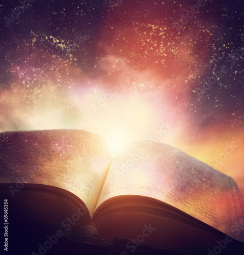 Photography Open old book merged with magic galaxy sky, stars