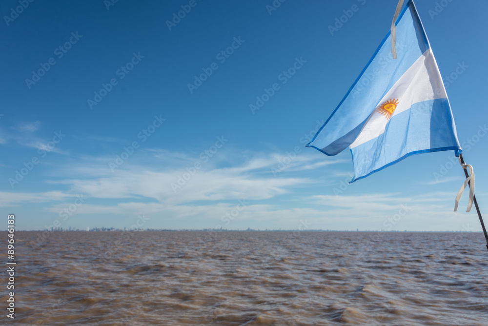 Fototapeta premium Sailing Buenos Aires city. Argentinean Flag waving at Rio de la