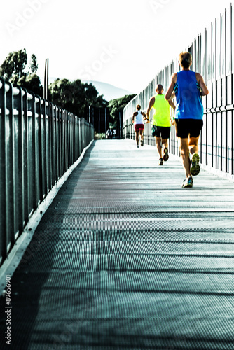 runners crossing a steel bridge