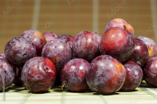 Freshly harvested red plums with natural wax bloom