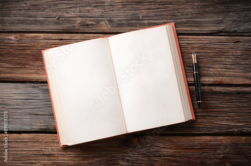 libro aperto con penna stilografica sul tavolo di legno photo