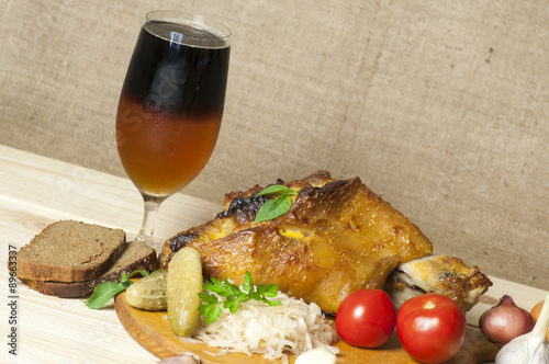 Roasted pork leg served with sauerkraut and sliced beer photo