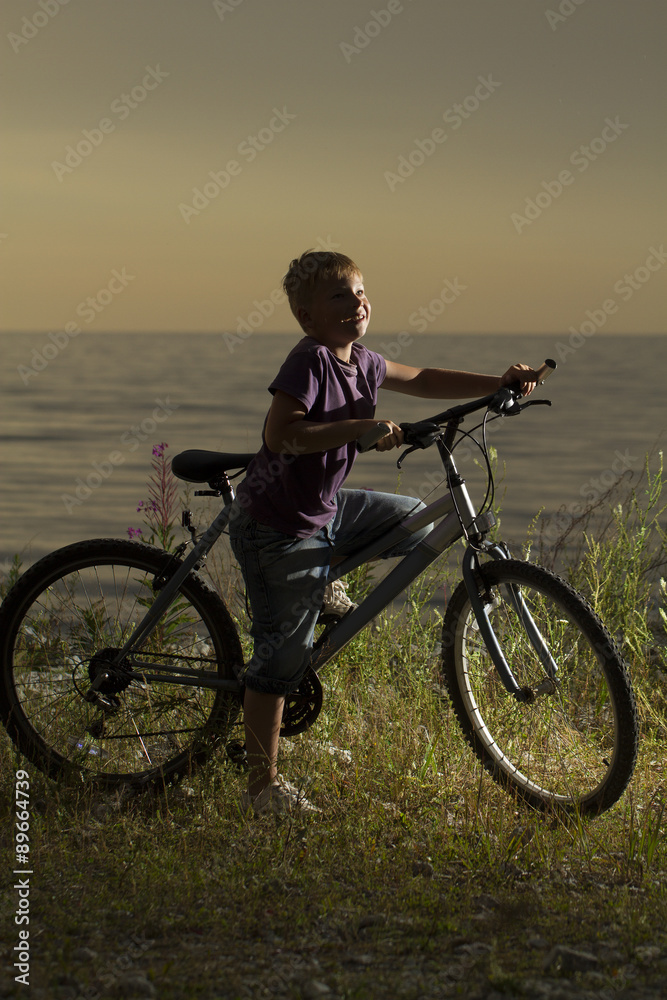 young boy with a bicycle in nature rests. young boy with a bicycle in nature rests.