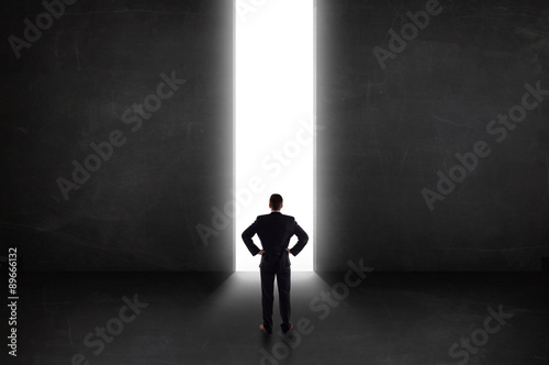 Business person looking at wall with light tunnel opening © ra2 studio