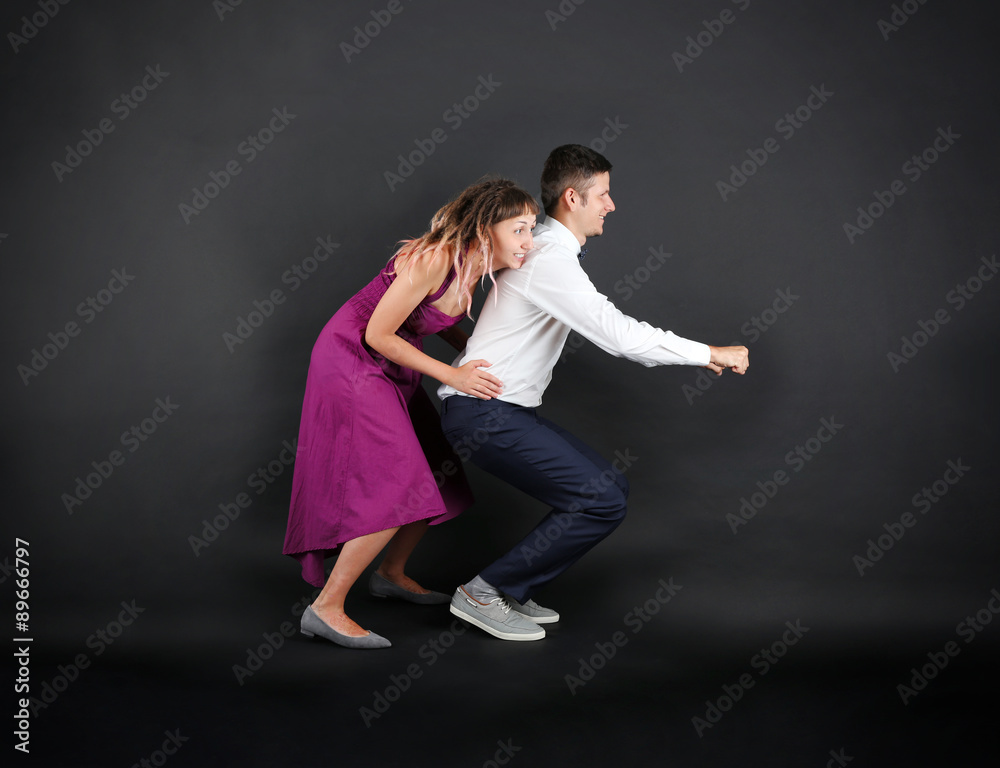 Funny young couple on black background Funny young couple on black background
