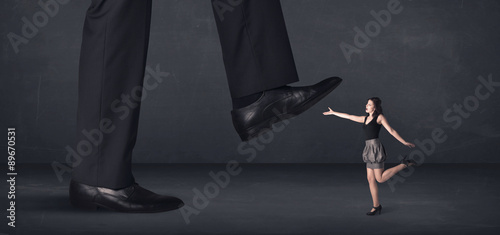 Giant person stepping on a little businesswoman concept
