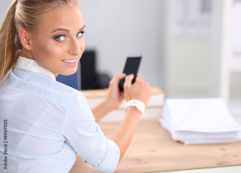 Businesswoman sending message with smartphone sitting in the Businesswoman sending message with smartphone sitting in the