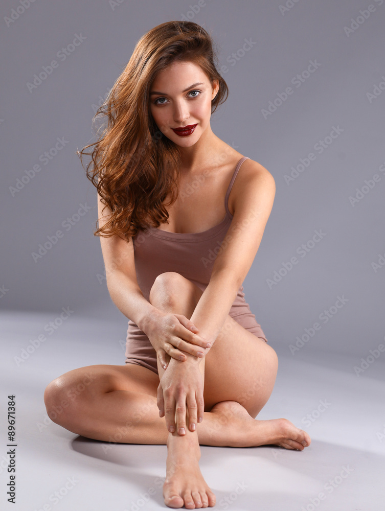 Beautiful barefoot woman sitting on the floor 