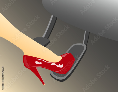 A woman's foot in a high heeled red shoe pressing the gas pedal in a car