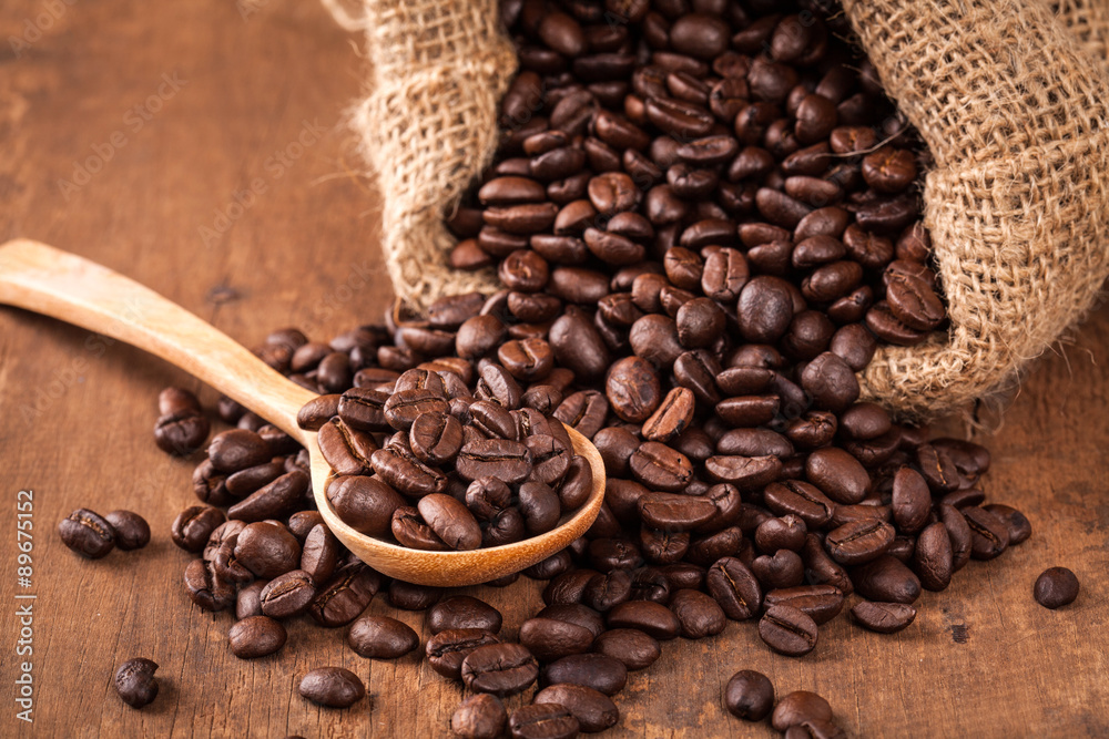 Fototapeta premium coffee bean on the wood table with spoon and sack
