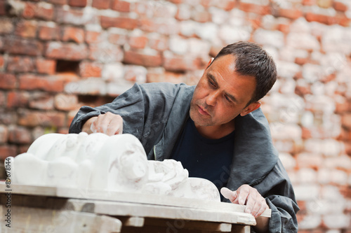 craftsman restorer working with gypsum model
