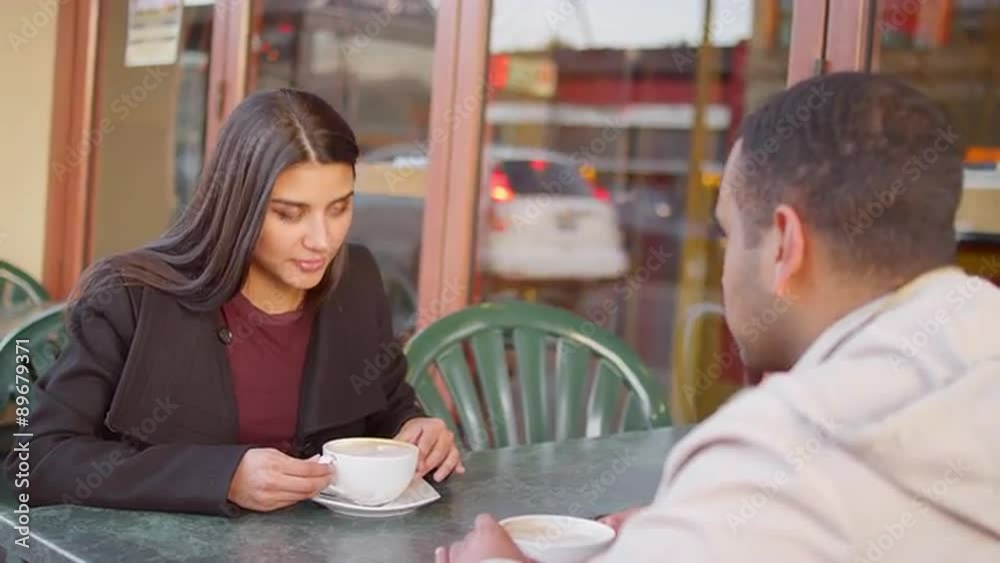A young couple enjoying coffee outside of a downtown cafe A young couple enjoying coffee outside of a downtown cafe