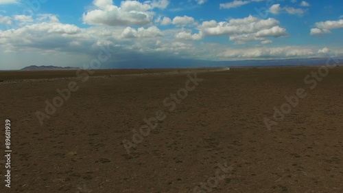 Aerial view flying over Tanzania desert. Car moving on road. Africa. Travel tourism adventure in wild nature camera bird eye view.