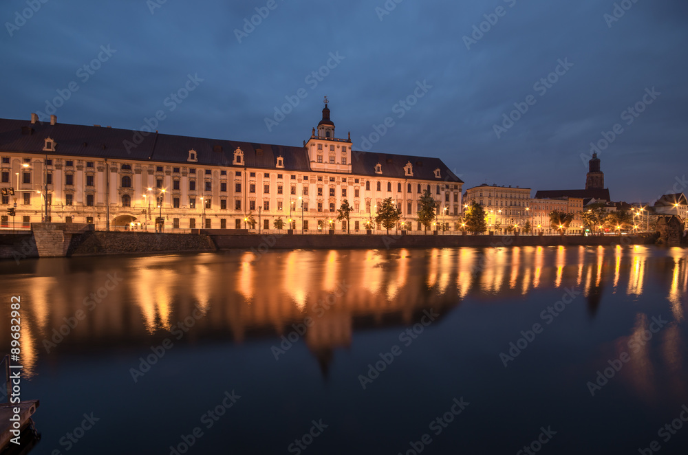 Odra river waterfront in Wroclaw, Poland, with main university building, in early morning, seen from University Bridge