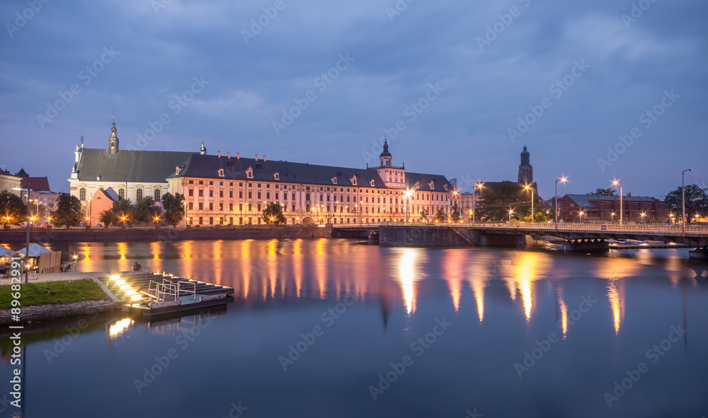 Odra river waterfront in Wroclaw, Poland, with university church and main university building, in early morning, seen from Malt Island (Wyspa Slodowa)