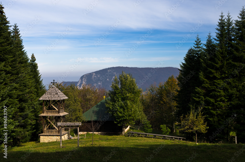 Meadow in front of an old wooden church at mount Bobija