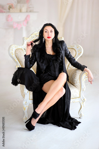 Luxury brunette, woman in black dress alluring posing on