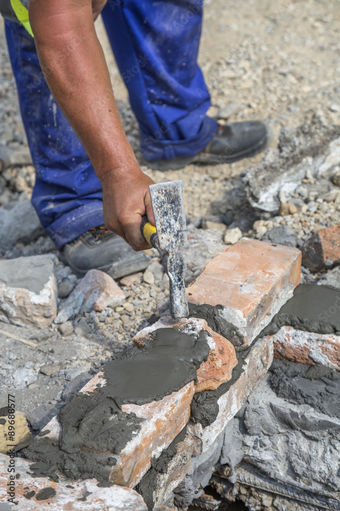 Mason hand using masonry hammer Mason hand using masonry hammer