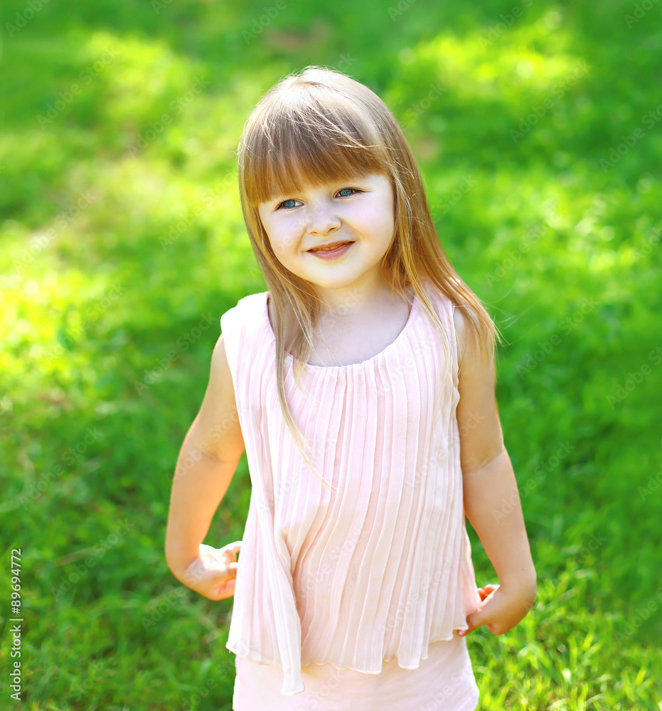Portrait of cute child little girl on the grass in summer day Portrait of cute child little girl on the grass in summer day